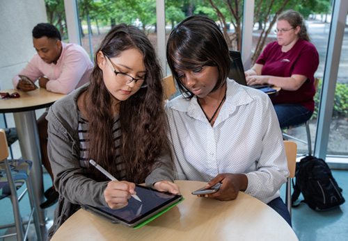 two students looking at an iPad