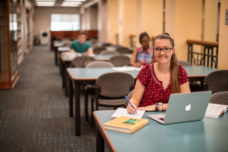 Three students studying in the library