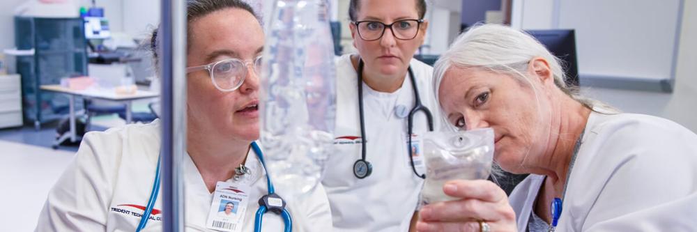 Three Trident Tech medical students working together in a lab.