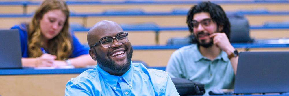 Students smiling in a lecture hall.