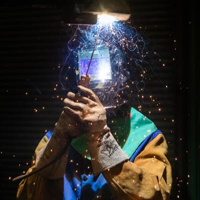 A person in full safety gear mid welding project.