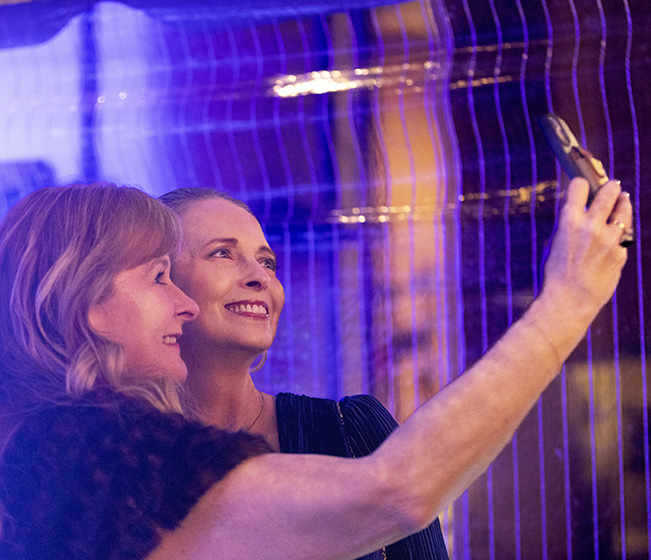 Two guests taking a photograph together.