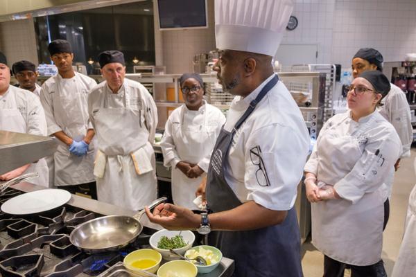 Chef Kevin Mitchell instructs culinary students while cooking