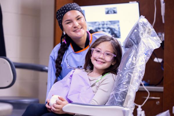 Dental student with female child in clinic
