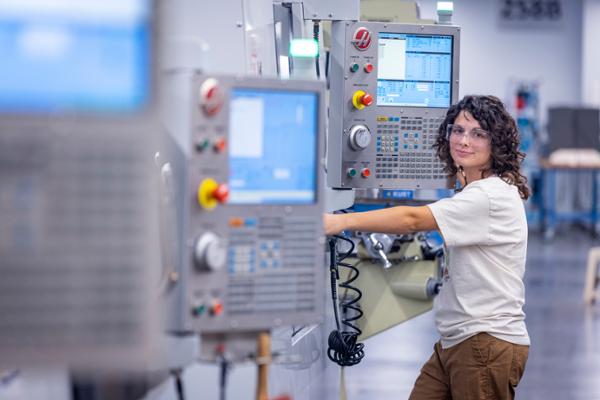 female student programming CNC machine