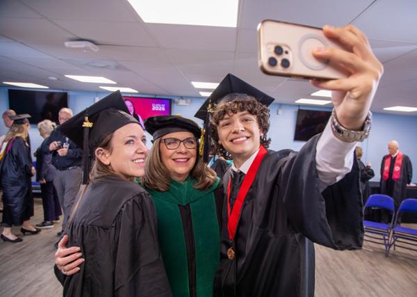 Dr. Wood poses with the 2026 graduation speakers A college graduation selfie with three people