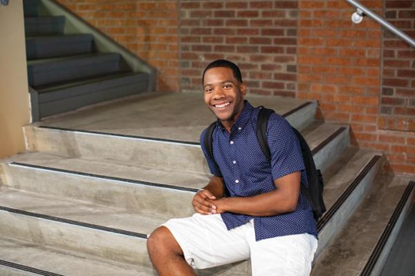 Male student sitting on steps 