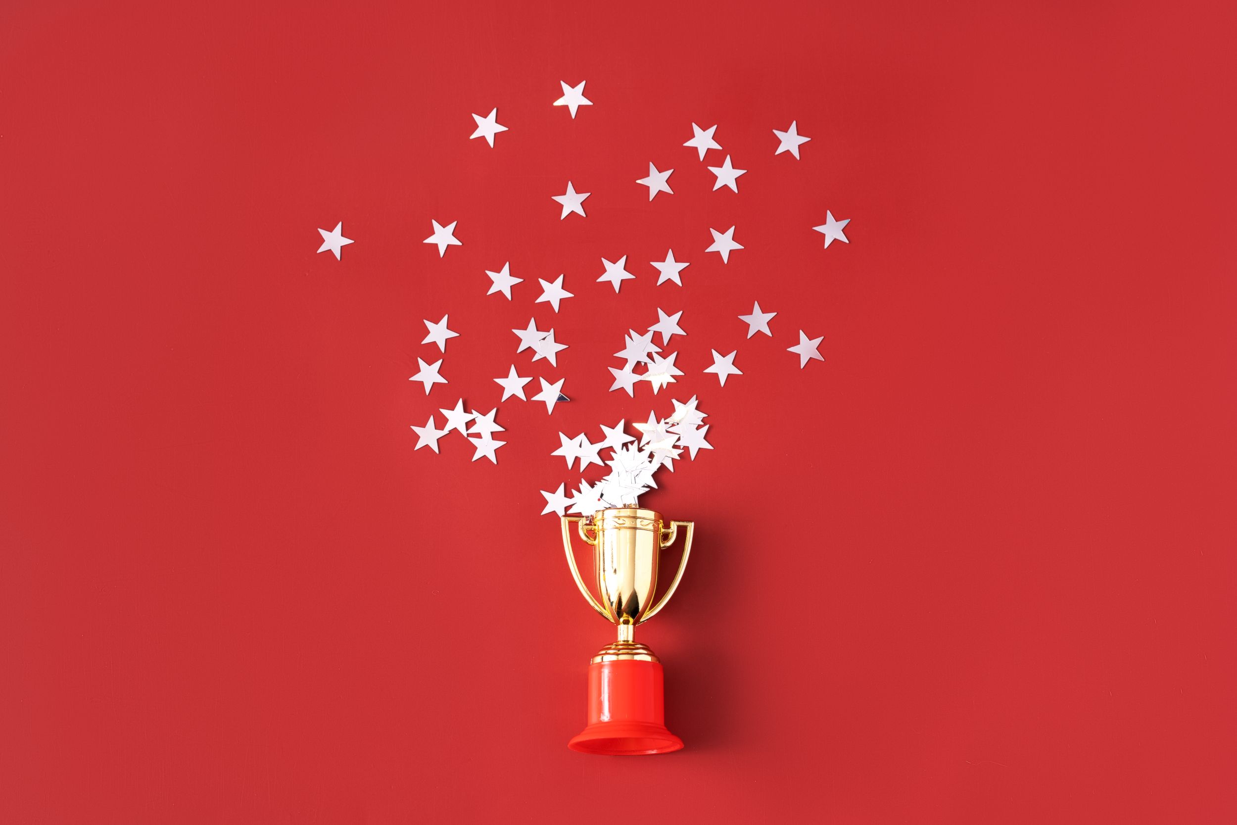 Golden trophy with stars on red background
