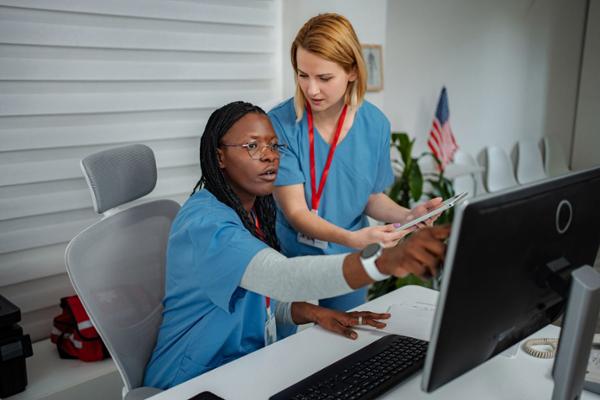 Healthcare professionals review file on computer