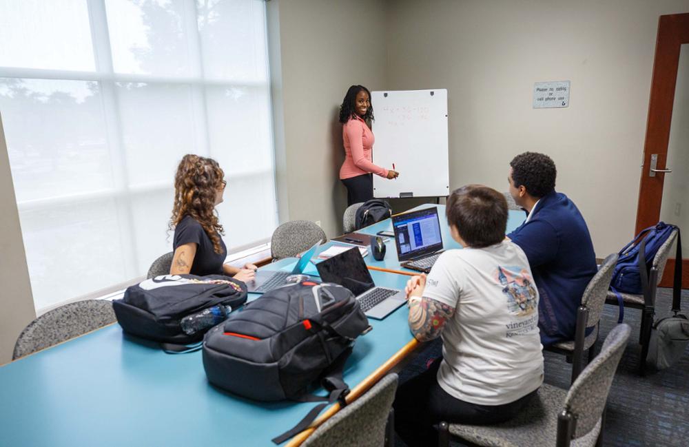student presenting in a library conference room